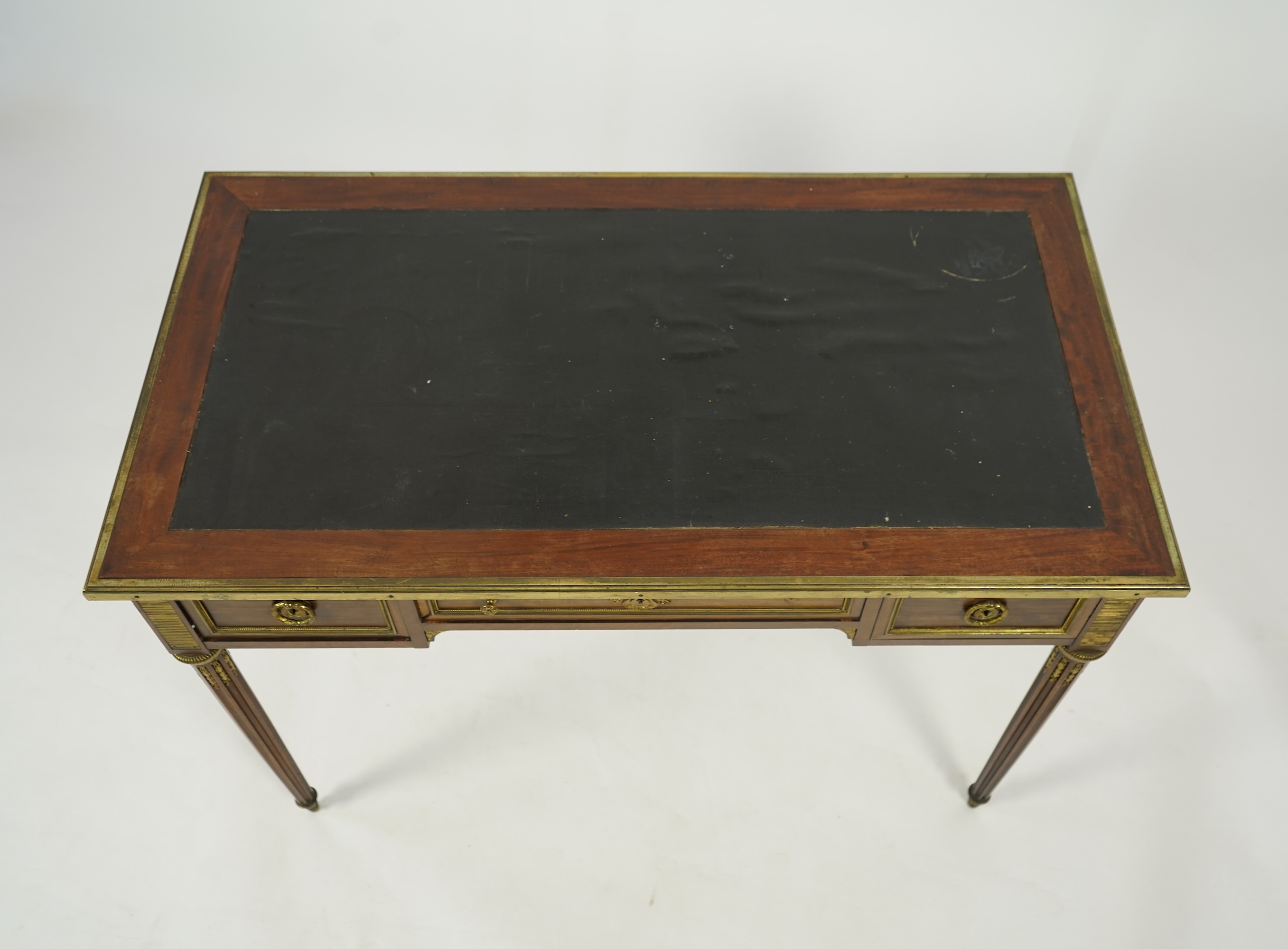 An early 20th century Louis XVI style brass mounted mahogany writing table
